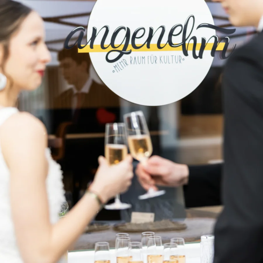 Brautpaar stößt im Angenehm mit Sekt an